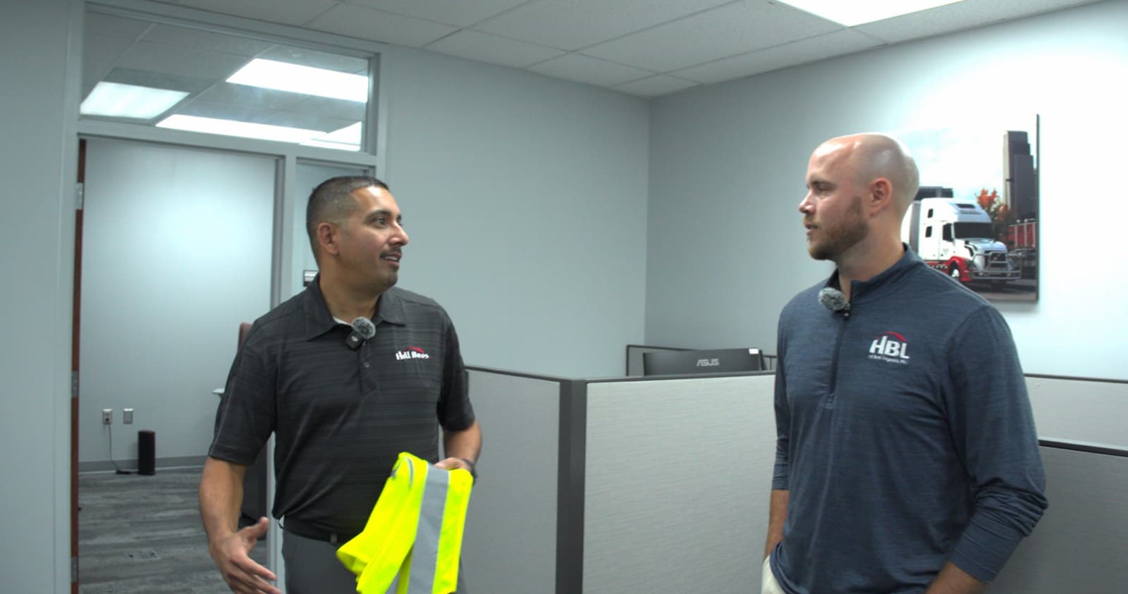 Two brokers talking between desks in a freight office
